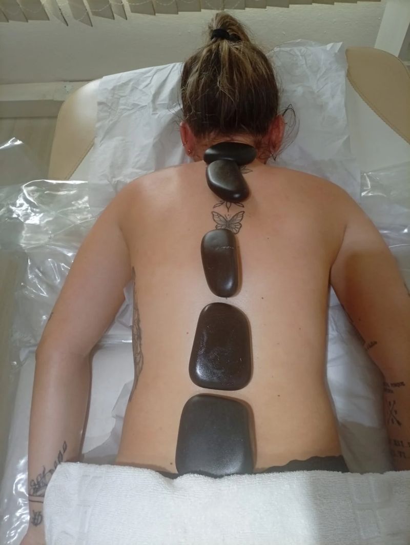 Massagem relaxante com pedras quentes nas costas